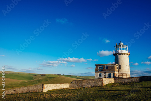 The Belle Tout Lighthouse located at Beachy Head  East Sussex  United Kingdom with a clean blue sky and clouds on the scene - Seven Sisters National Park