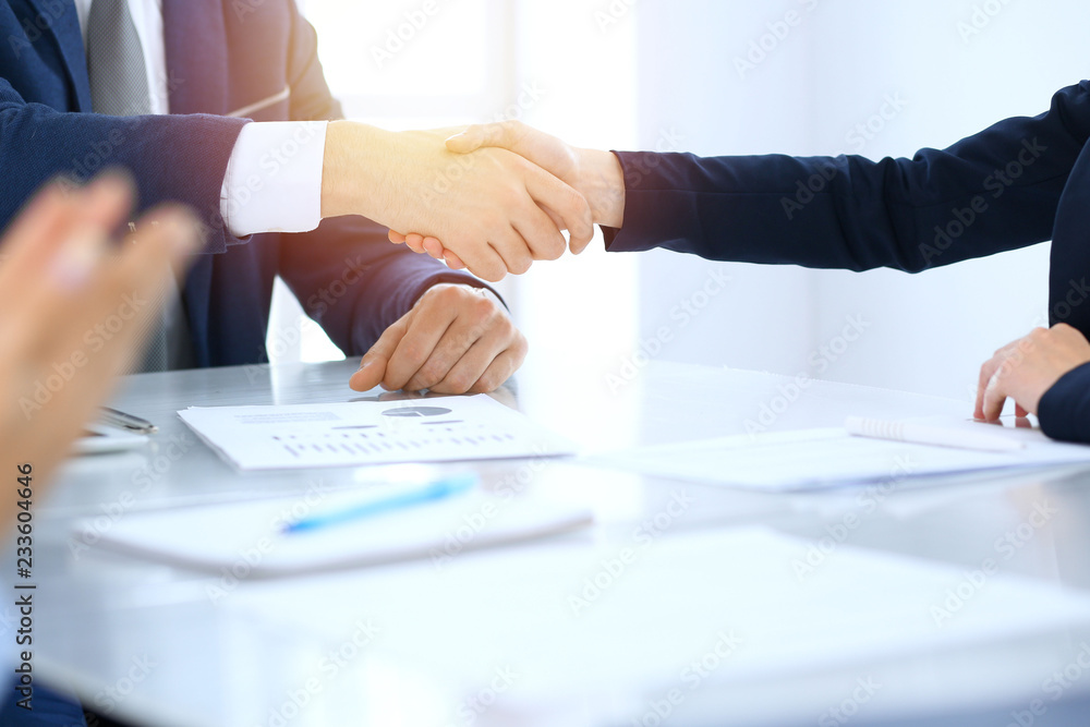 © rogerphoto - Group of business people or lawyers shaking hands finishing up a meeting , close-up. Success at negotiation and handshake concepts