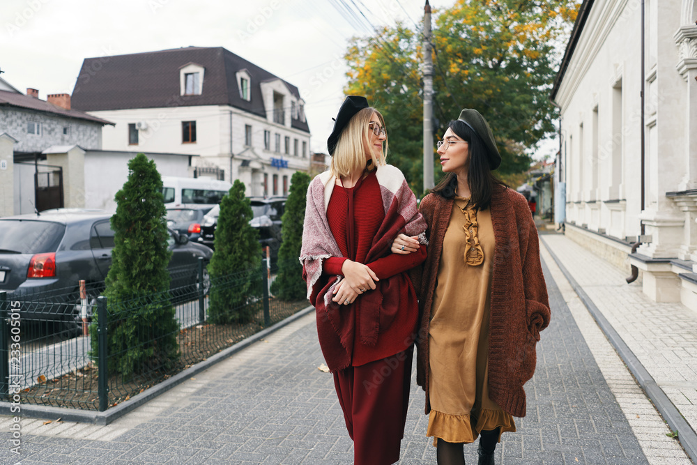 Women models in elegant autumn clothes and glasses over urban ci Women models in elegant autumn clothes and glasses over urban ci
