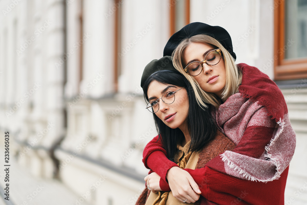 Two friends in casual warm outfits outdoors portrait