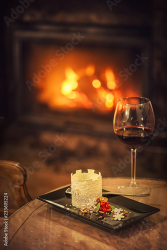 beautiful winter dessert like castle with snowflakes and fruits served on white plate with glass of red wine, product photography for patisserie