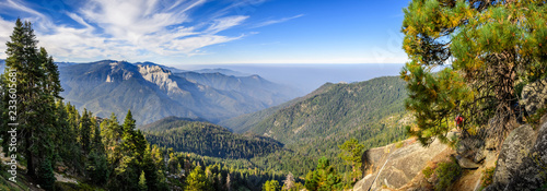 Landscape in Sequoia National Park in Sierra Nevada mountains on a sunny day; smoke from wildfires visible in the background, covering the Fresno area; photo
