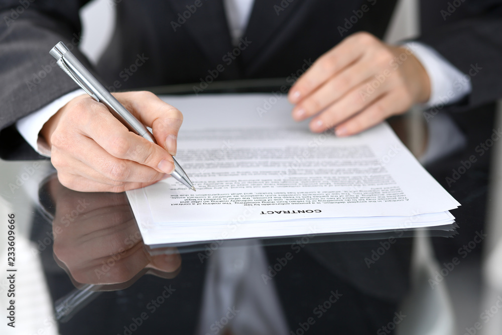 Close-up of female hands with pen over document of contact, business concept Close-up of female hands with pen over document of contact, business concept