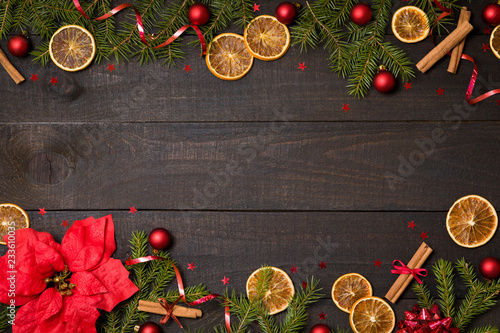 Dark rustic wooden table background with Christmas decoration and fir frame. Top view with free space for copy text