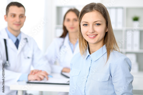 Friendly male doctor on the background with patient in hospital