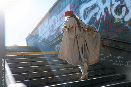 Model on the move while posing for new collection in long coat