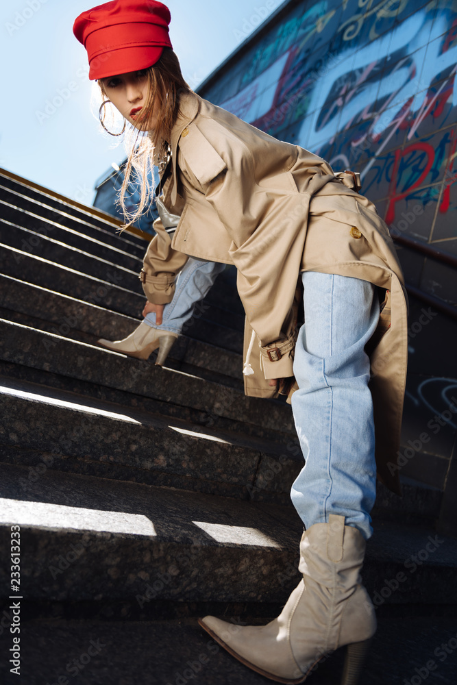 Professional fashion model posing in high-heeled boots on the stairs Professional fashion model posing in high-heeled boots on the stairs