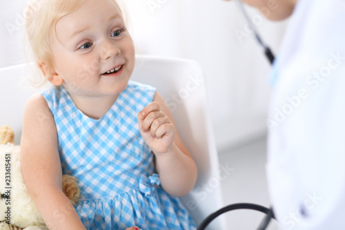 Doctor examining a little blonde girl with stethoscope.Medicine and healthcare concept