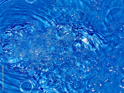 lots of small bubbles in running water, beautiful blue background