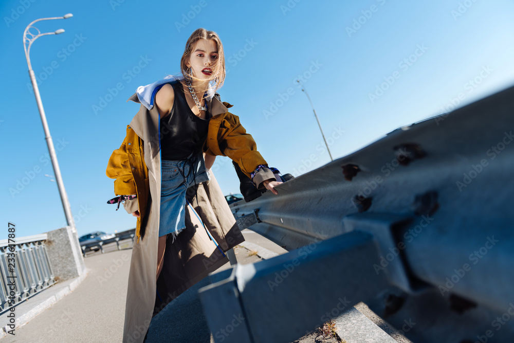 Naklejka premium Low angle of young appealing photo model posing promoting clothes