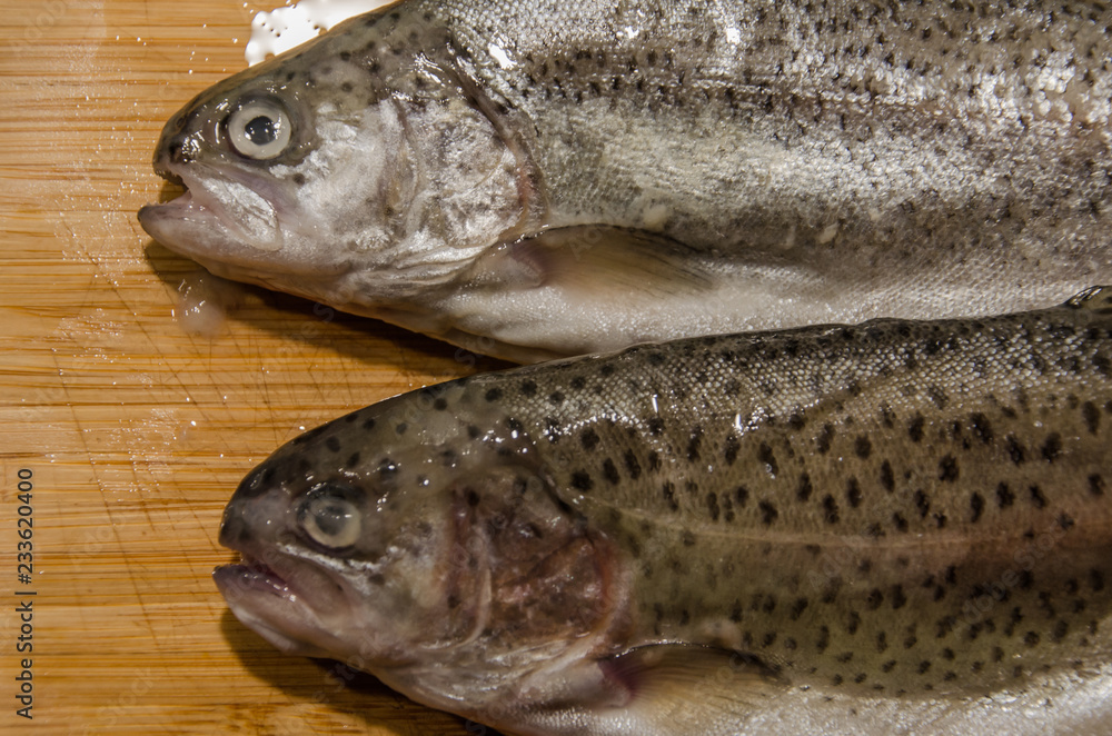 Rainbow trout fish on wooden table ready for cooking stuffed with lemon Rainbow trout fish on wooden table ready for cooking stuffed with lemon