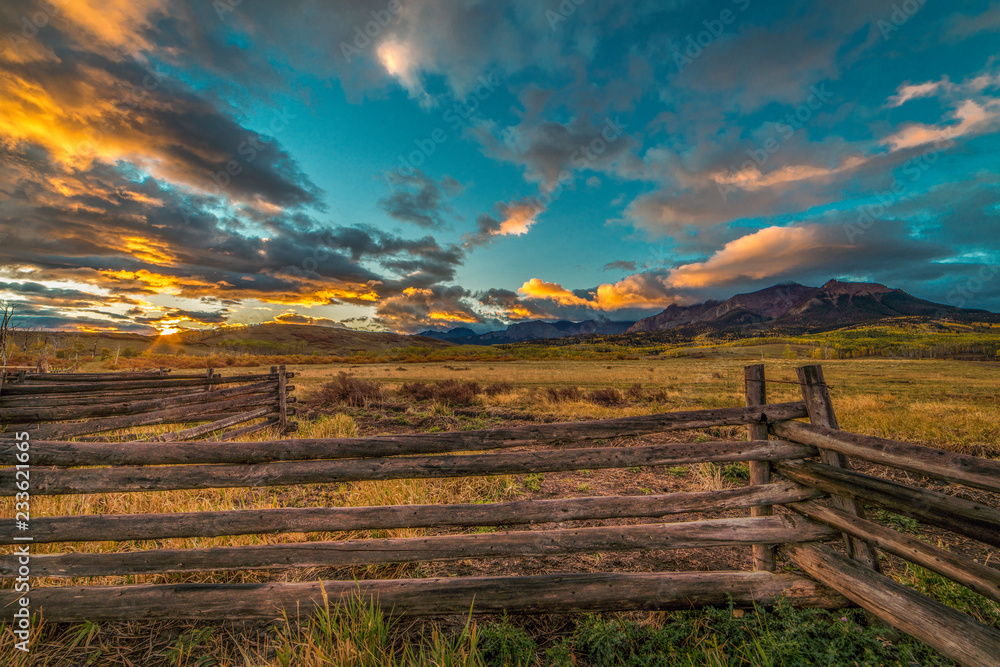OCTOBER 3, 2018, RIDGWAY COLORADO USA - Sunrise on worm western fence in front of San Juan Mountains in Old West of Southwest Colorado near Ridgway - obrazy, fototapety, plakaty 