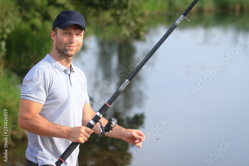 Portrait of fisherman with fishing rod on lake