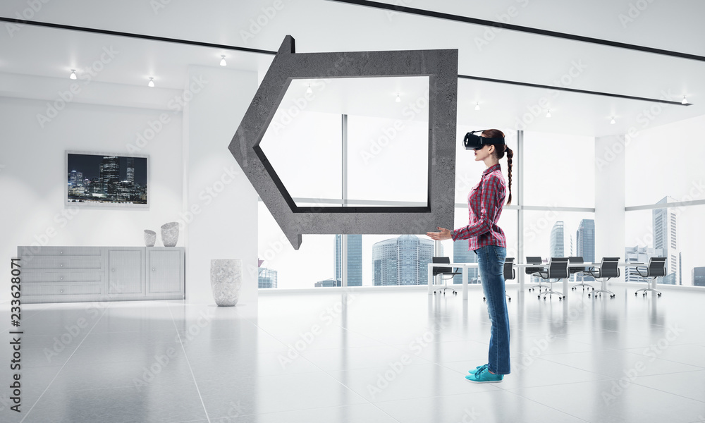 Fototapeta premium Girl in virtual reality mask experiencing virtual technology wor