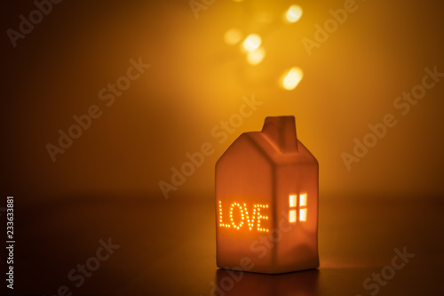 Lovely festive candle light house with LOVE inscription and window. Warm, pleasant and soft light. Love, comfort, quietness. Peaceful moment with your loved ones. Family gathering, festive season.