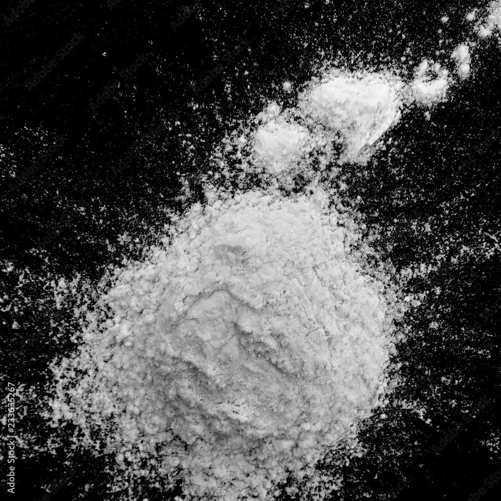 Isolated natural white flour powder texture effect on clean black background. Organic baking element close-up. Isolated natural white flour powder texture effect on clean black background. Organic baking element close-up.