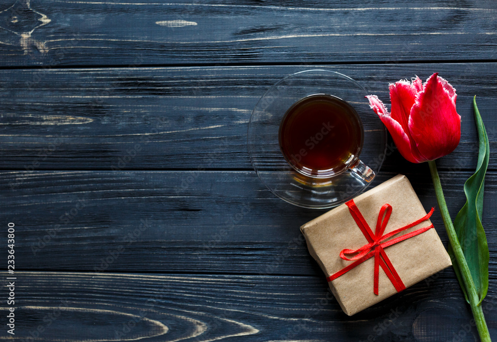 red tulip, box with red ribbon and cup of coffee on the gray wooden table. Valentines, spring background. floral mock up. with copyspace red tulip, box with red ribbon and cup of coffee on the gray wooden table. Valentines, spring background. floral mock up. with copyspace