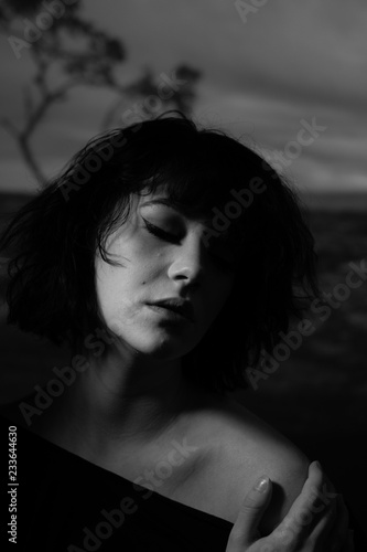 Noir retro female model against a moody dark desert landscape