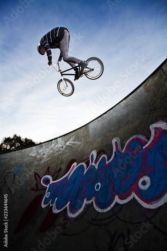 Photography Low angle view of man performing stunt while cycling on sports ramp