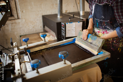 Fotografía Midsection of woman pressing ink on frame in workshop