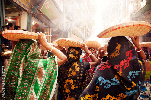 Fotografía Rear view of women carrying basket on head while walking