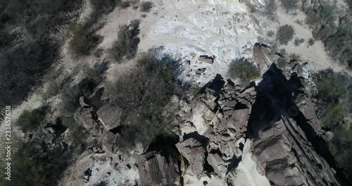 Aerial senital drone scene flying above rock formations that emerge from earth with angle. Top view of rocks of folded mountains. Native vegetation San Juan province, Huaco, Argentina photo
