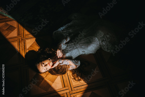 The elegant bride lying on the floor under the sun's rays