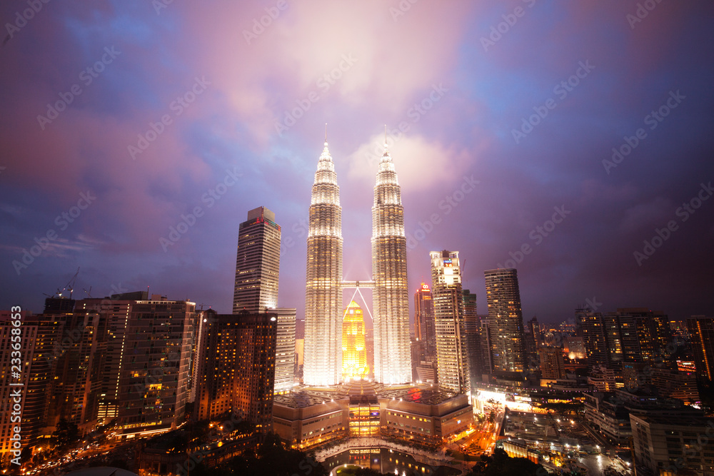 Fototapeta premium Illuminated PETRONAS Towers against dramatic sky