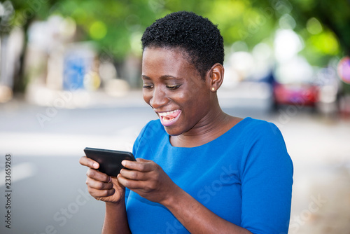 Close-up of young girl with mobile phone, happy.
