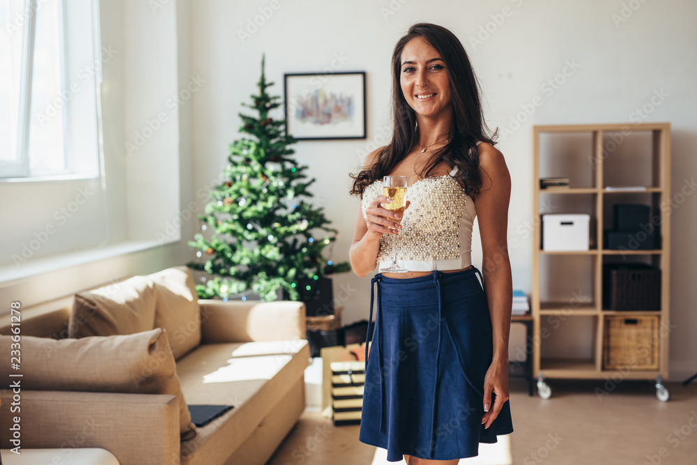 Christmas, New Year. Happy young woman with glass of champagne at home Christmas, New Year. Happy young woman with glass of champagne at home