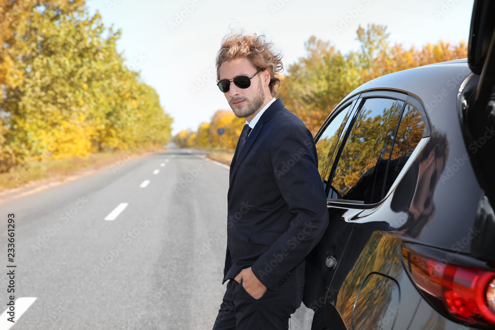 Young businessman near modern car on sunny day, outdoors Young businessman near modern car on sunny day, outdoors