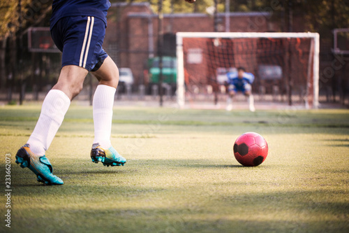 Photography Cropped image of man kicking ball at field
