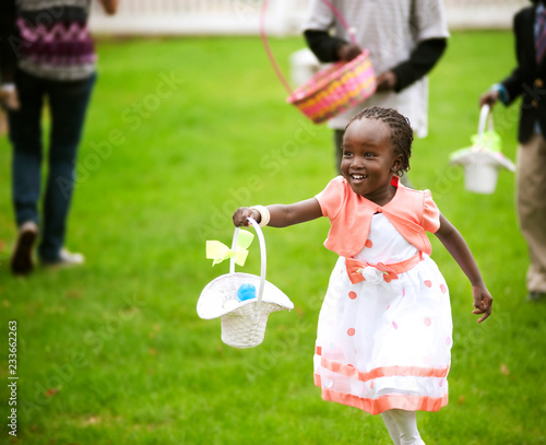 Happy girl holding basket of Easter eggs while running at park