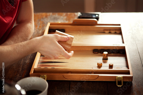 Quadro su tela Cropped image of man throwing dice cup at table