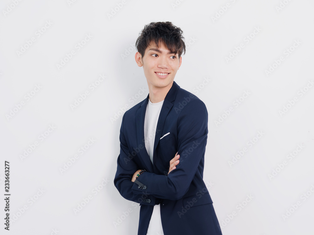 Portrait of handsome Chinese young man in dark blue leisure suit posing against white wall background. Smiling with arms crossed, looks confidence. Portrait of handsome Chinese young man in dark blue leisure suit posing against white wall background. Smiling with arms crossed, looks confidence.