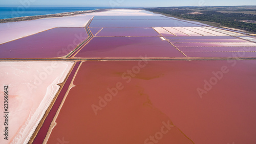 Spectacular aerial view of Pink Lakes of the salt mine at Port Gregory in Western Australia with the Indian ocean in the background.