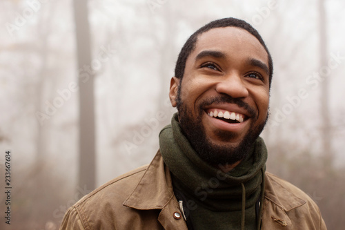 Smiling man looking away in forest