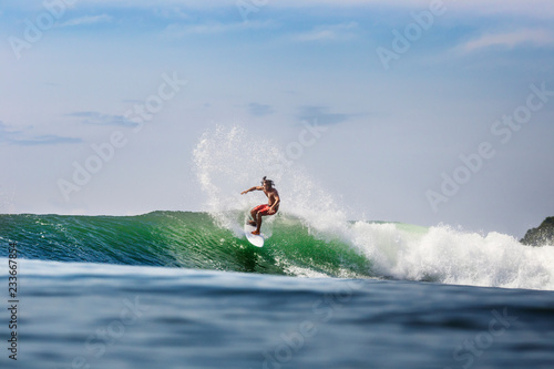 Canvas Print Man surfing on wave in sea against sky
