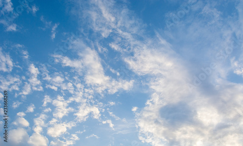 Blue bright summer sky with fluffy clouds on a sunny day