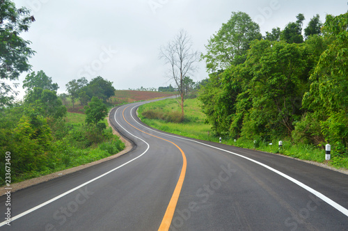 curve road driving / asphalt of road for car travel transportation on mountain - countryside road curve with line to the mountains green tree forest on roadside © Bigc Studio