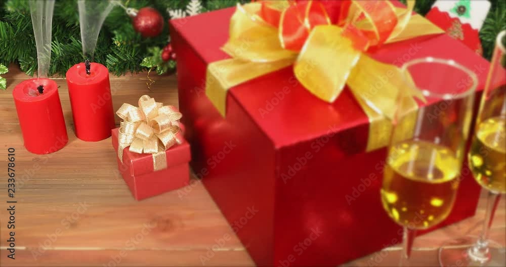 VDO of candle being extinguished, there is small and big gift boxes, glasses of white wine, on wooden table, pine branches with beautiful ornament behind it, concept for Christmas festival. VDO of candle being extinguished, there is small and big gift boxes, glasses of white wine, on wooden table, pine branches with beautiful ornament behind it, concept for Christmas festival.