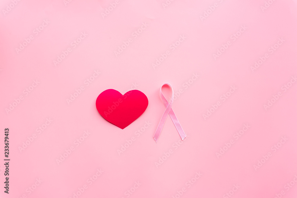 Breast cancer. Mammalogy concept. Symbolic pink ribbon near heart sign on pink background top view copy space