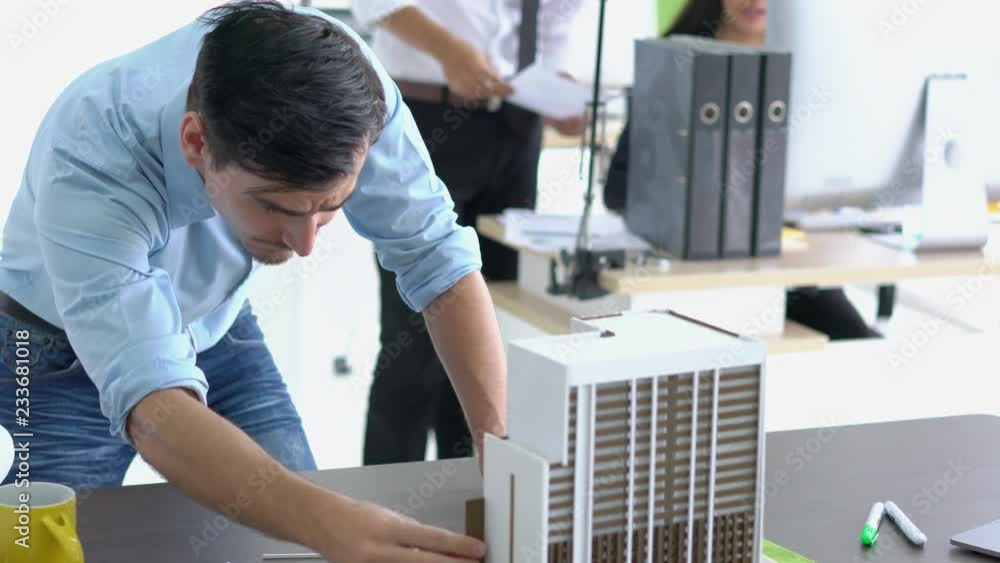 Architects male are working on a building model at modern office. Designer are developing architecture. concept of construction, development and creative idea.