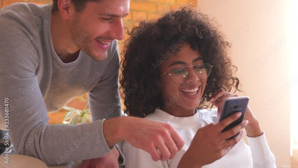 Happy couple using mobile phone at home Happy couple using mobile phone at home