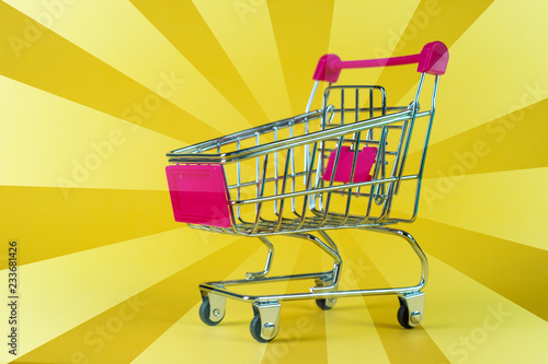 Shopping cart or supermarket trolley on yellow background, business finance shopping concept.