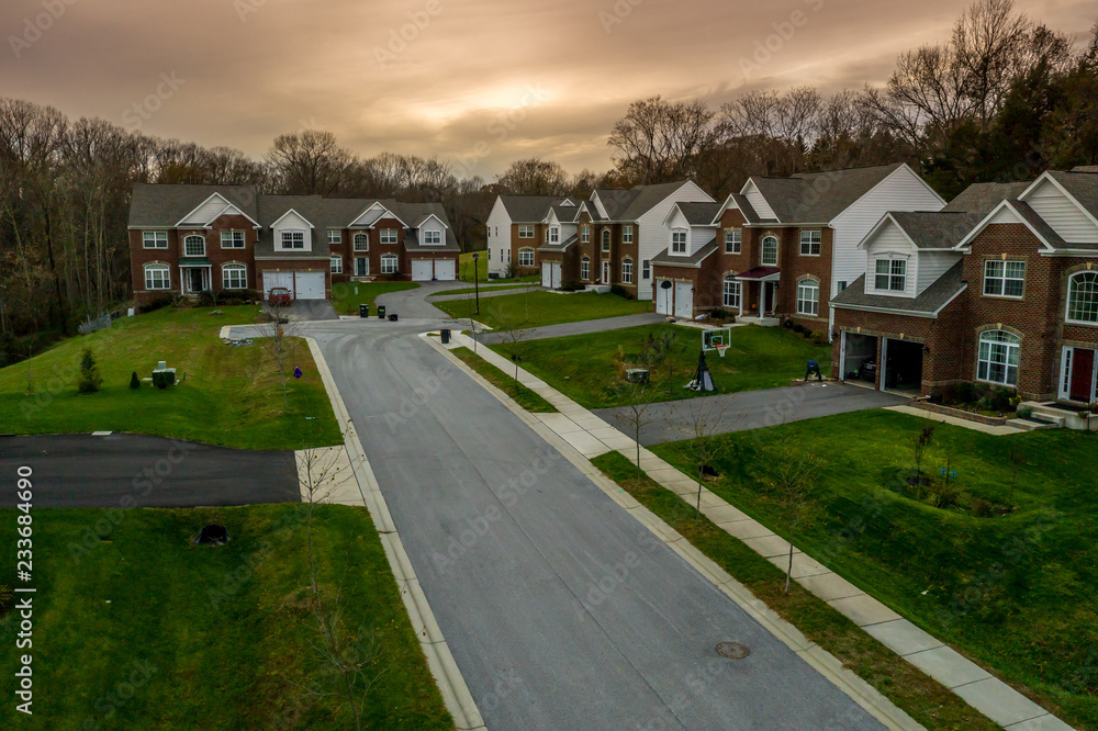 Aerial panorama of a row of newly constructed two story single family homes in a new construction middle class real estate in Maryland with sidewalk Aerial panorama of a row of newly constructed two story single family homes in a new construction middle class real estate in Maryland with sidewalk