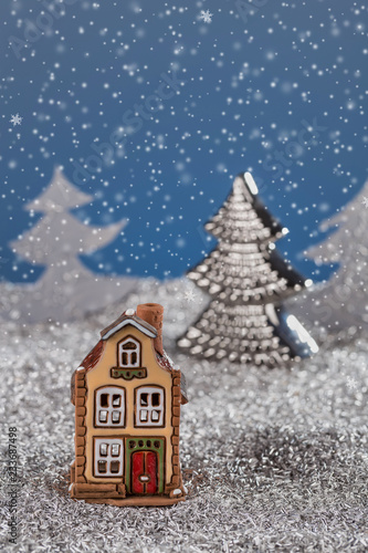 Miniature toy house in the Christmas story against the snow. Christmas card, new year card.