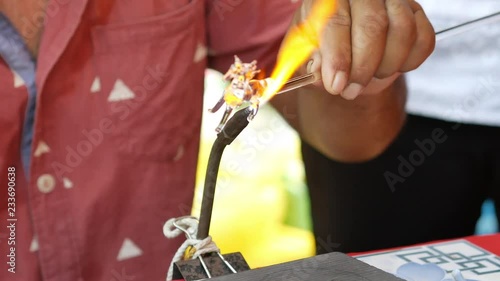 Blowing glass by fire to create a horse shape.
