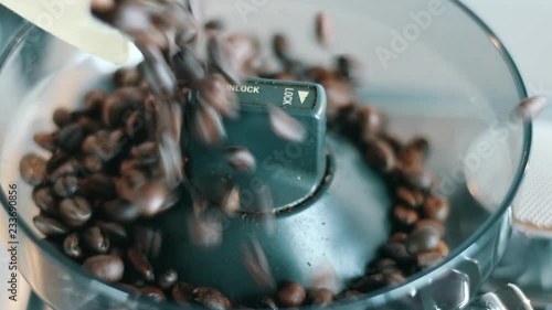 Pouring coffee beans gently into Grinder evenly top view photo