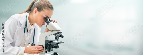 Foto Scientist researcher using microscope in laboratory